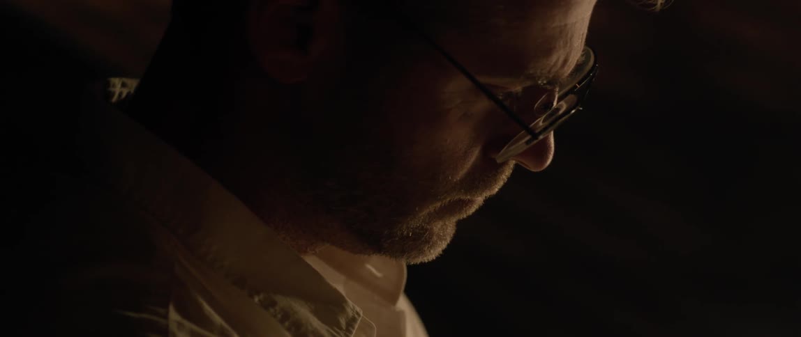 A man is looking at something in a dark room