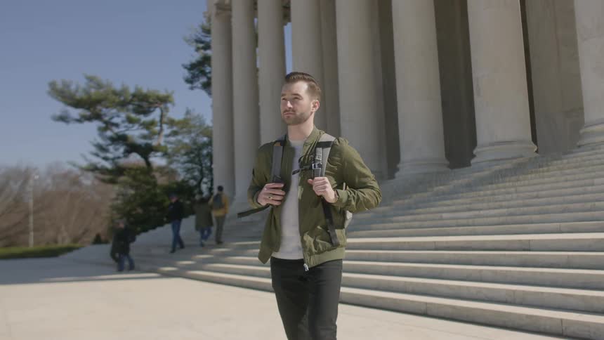 Man with backpack walks away from lincoln memorial