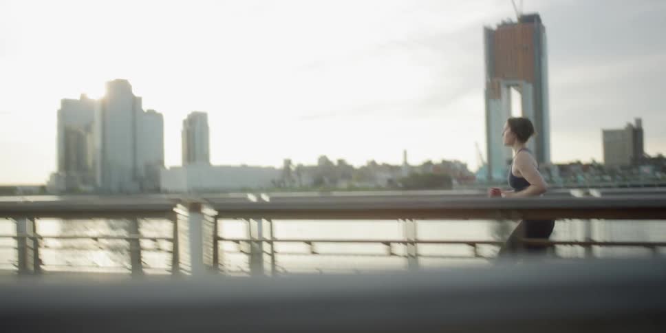 Woman running beside urban river