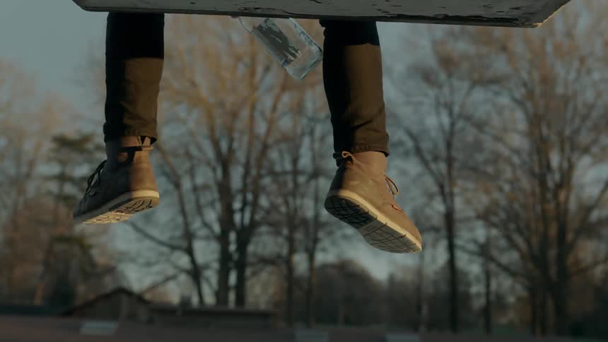Feet and water bottle dangling off a ledge