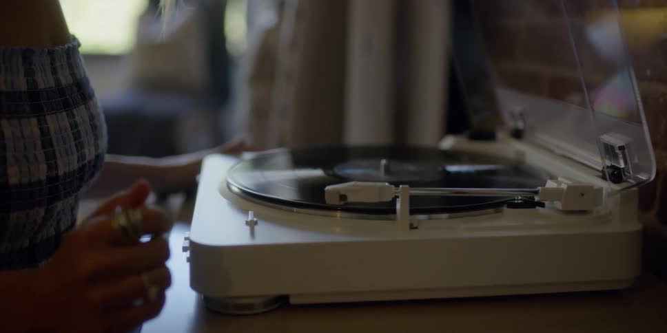 Woman playing a record at home in the afternoon