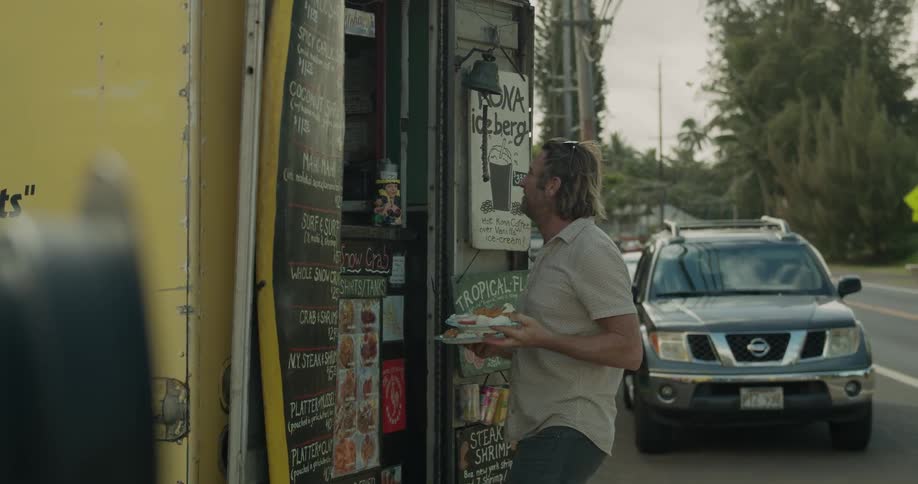 Two men get food from a food truck