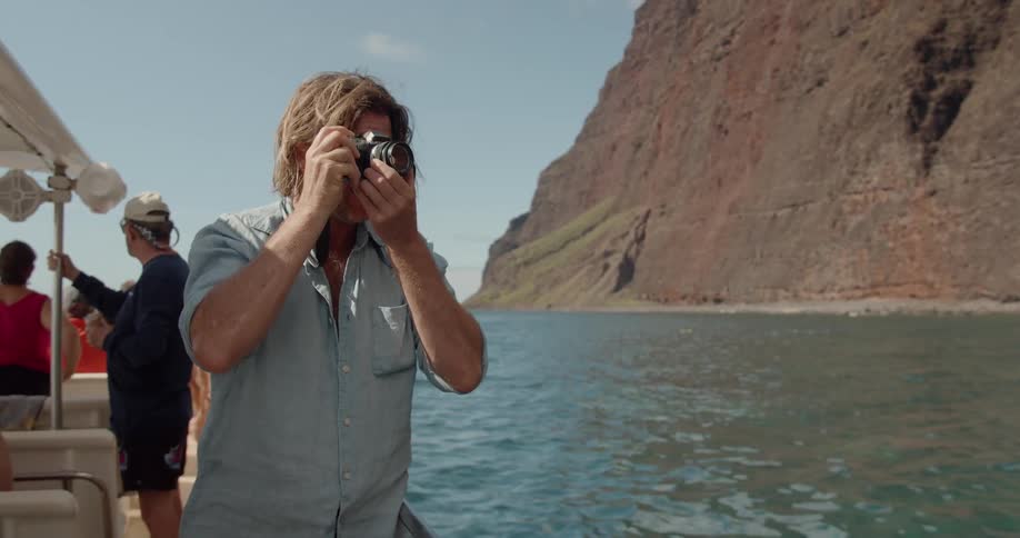 A man takes a photo from the back of the boat