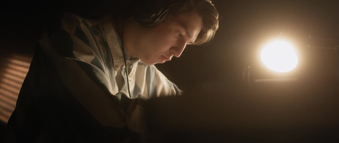 Man wears headphones while sitting at a desk