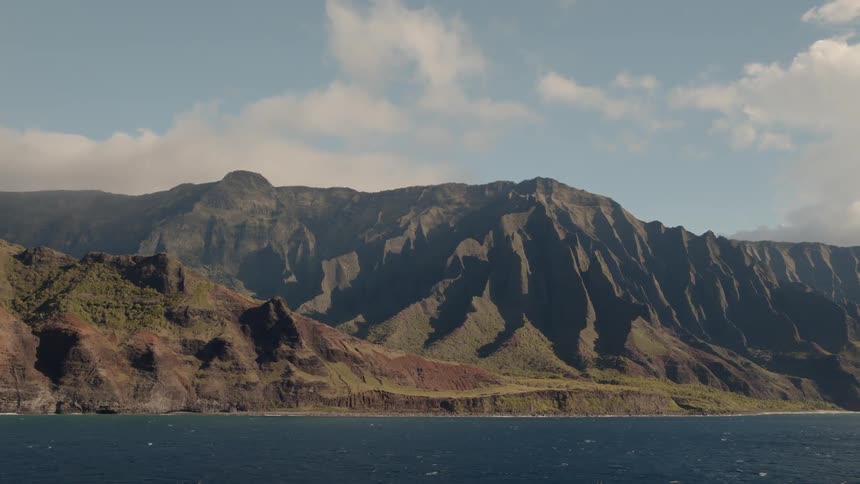 Clouds are drifting over coastal cliffs during daylight