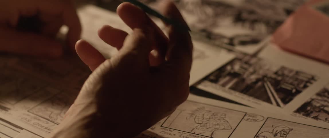 A man writes with a pencil