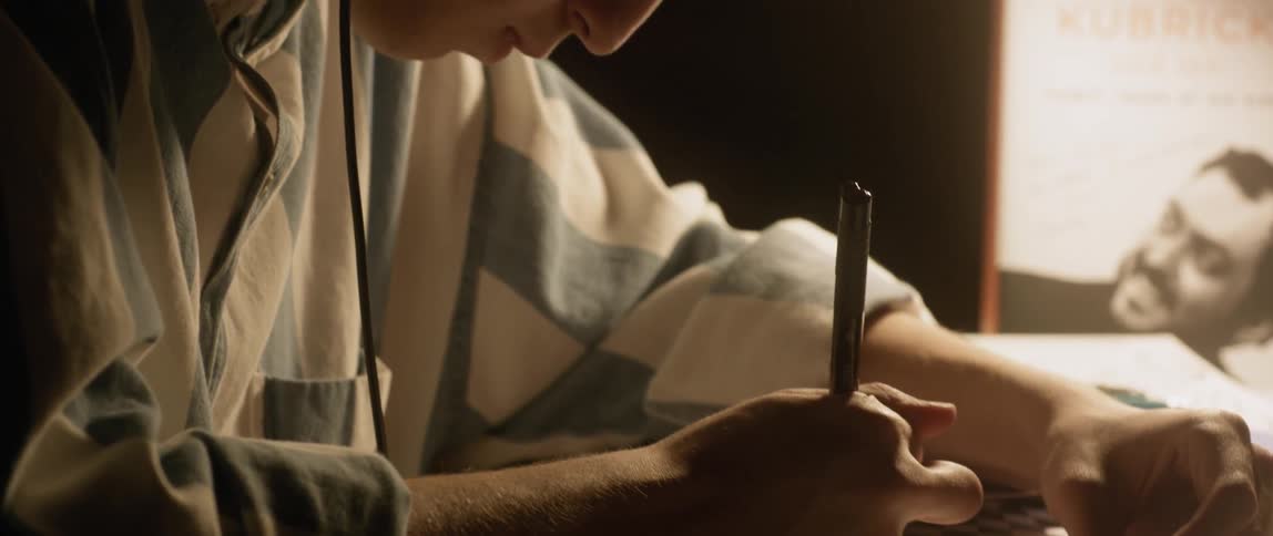 A man writes on paper on the desk