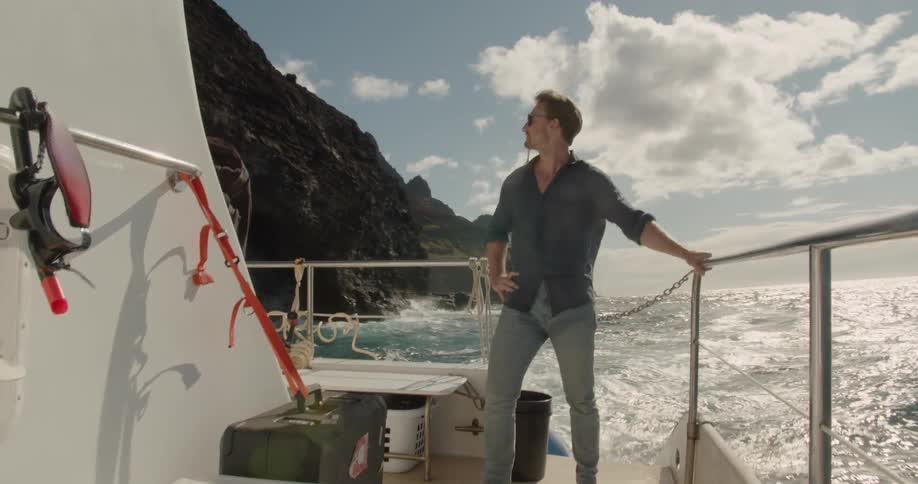 A man rides on the back of a speeding boat