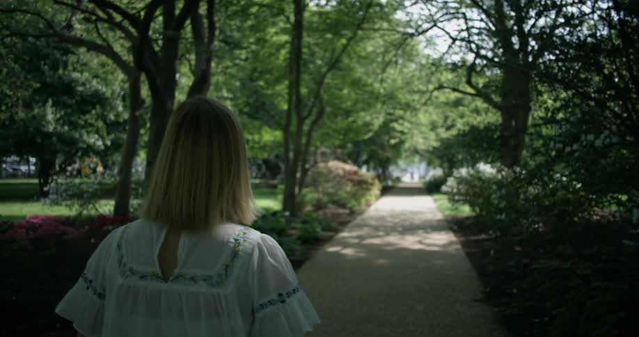 Woman walks in a park on a summer day
