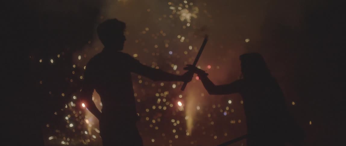 People celebrate using fireworks at night
