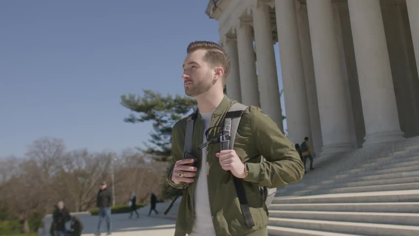 A man stands outside on a sunny day