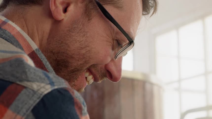 A man talks as steam rises over his face