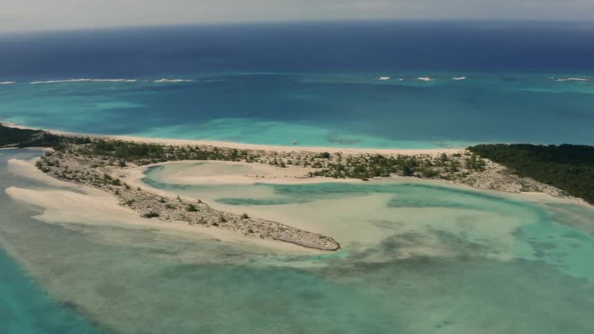 The small island is surrounded by blue water