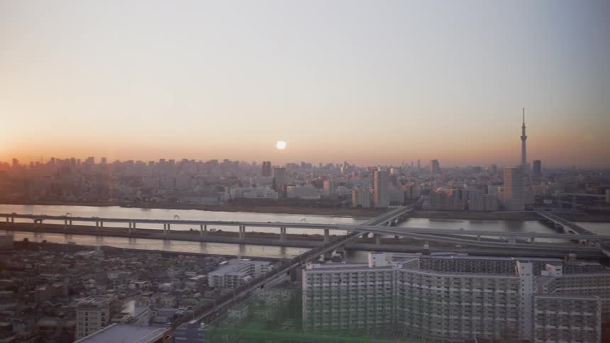 The sun is setting over the city by the bridge