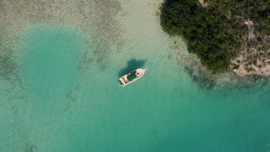 A boat is docked near the sand of the shore