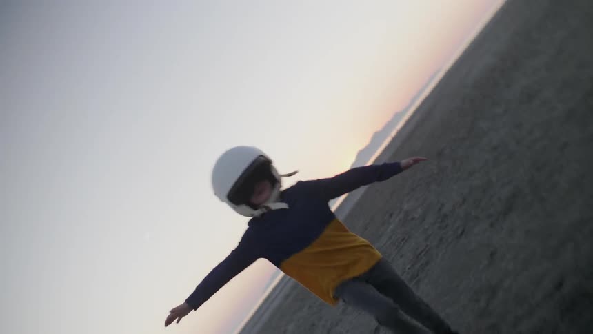 A child spreads his arms side to side as he runs