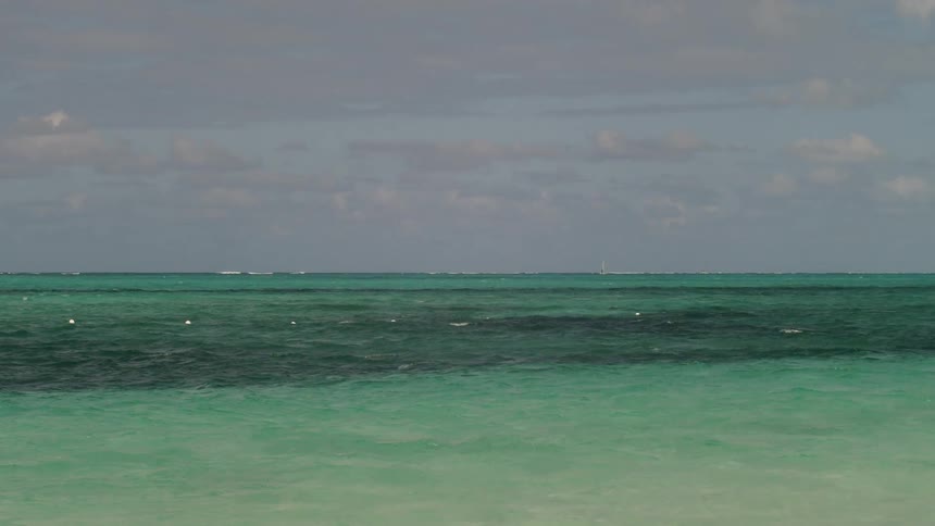 The green waters crash against the shore