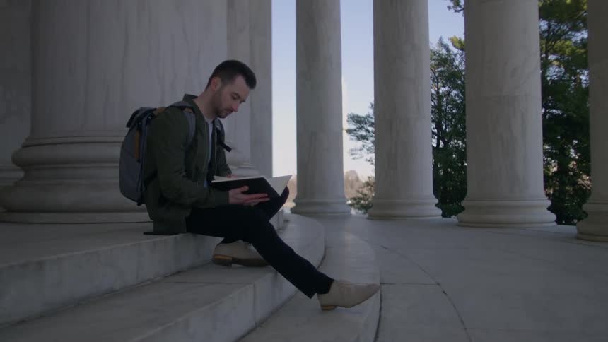 Man sits on steps of lincoln memorial reading