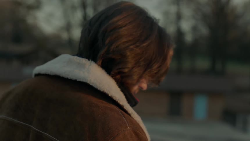 A man stands outside and hangs his head