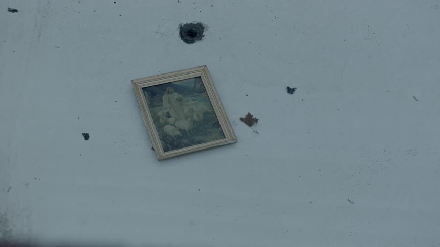 A photograph sits on the ground below