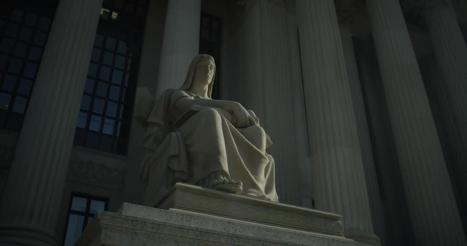 Bird flies over a statue that sits in front of some pillars