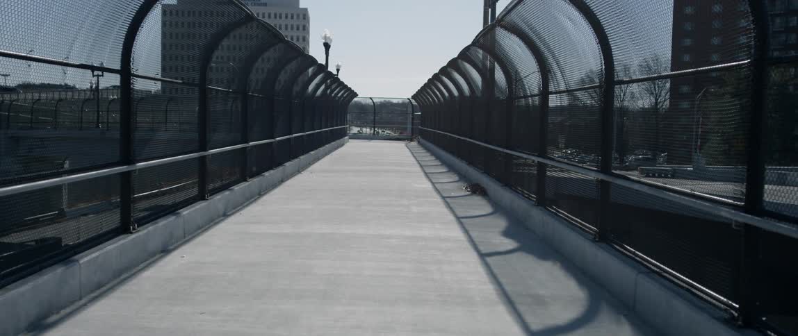Chain link fence covers each side of the walkway