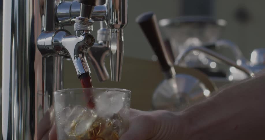 A person fills a glass from a tap