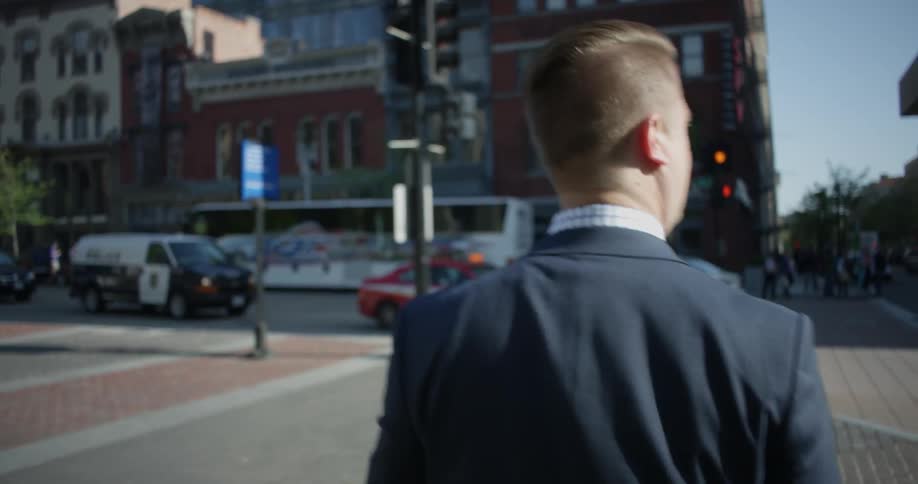 A man crosses the street on a sunny day