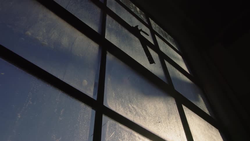 A tall window is in a dark room