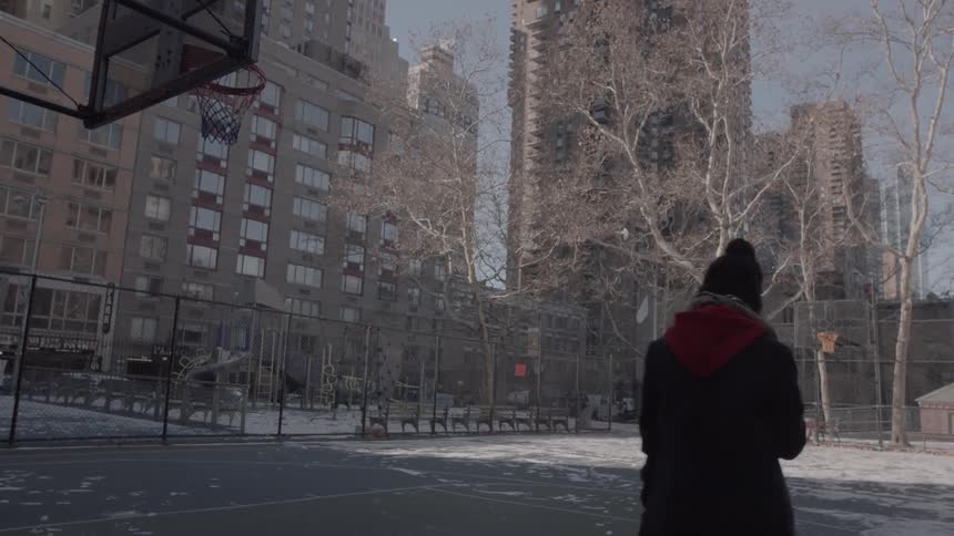 Person stands outside on a basketball court