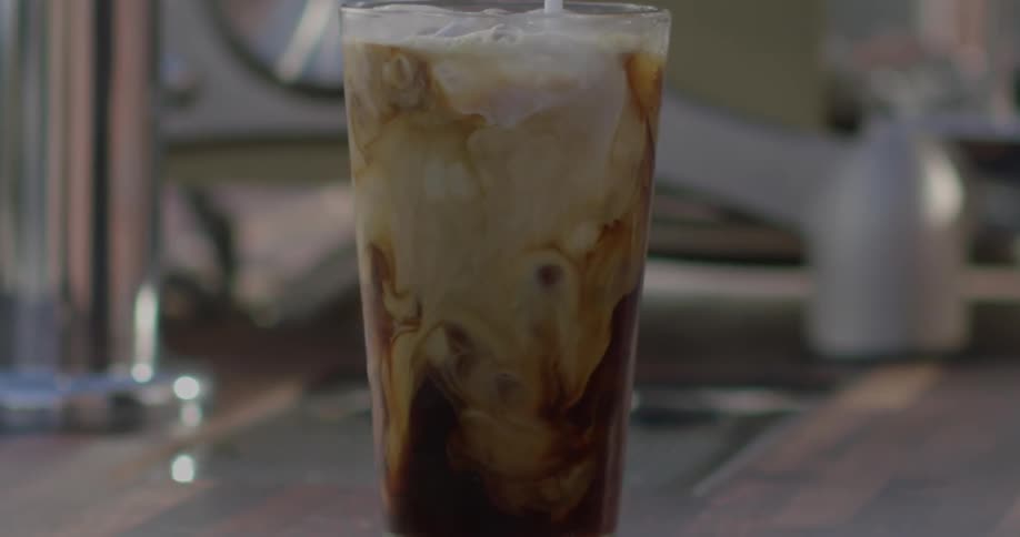 Cream is poured into an iced coffee