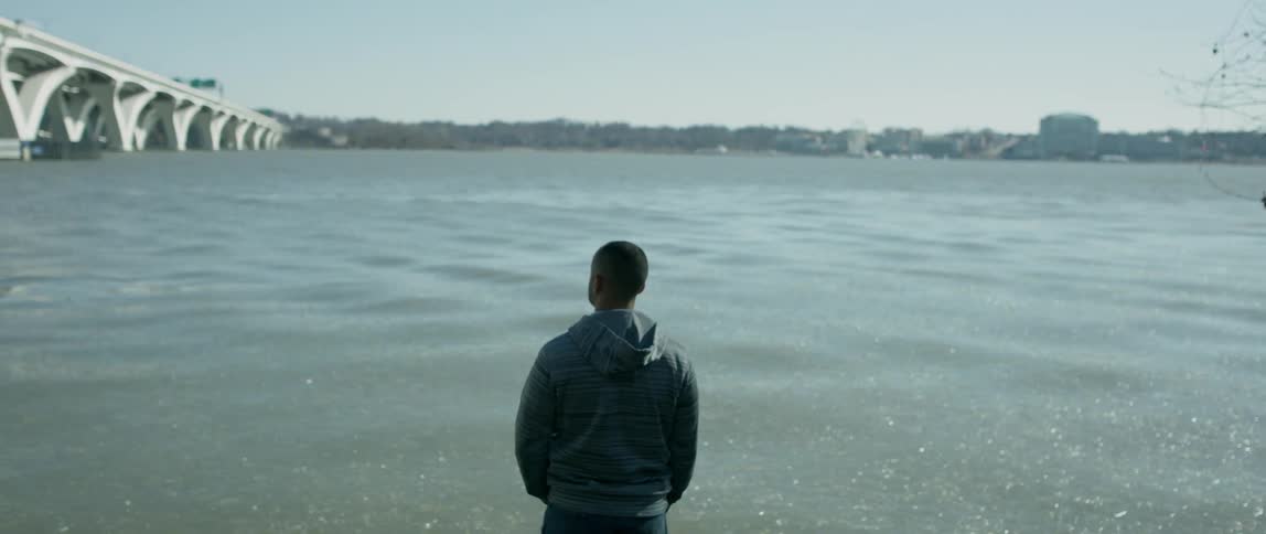 Man stands next to a rippling river