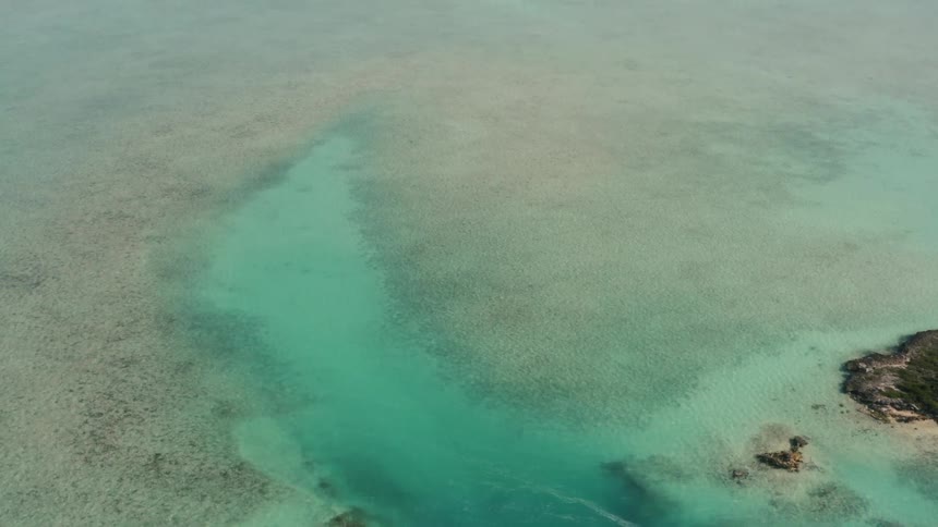 A boat is docked near the side of a small island