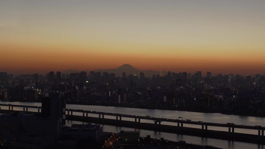 Cars drive on a city bridge at sunset