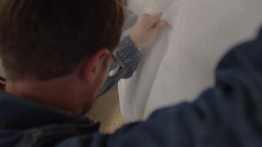 A man is pouring bags in a brewery