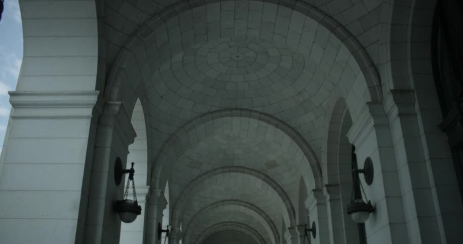 Lamps hang from the stone arches