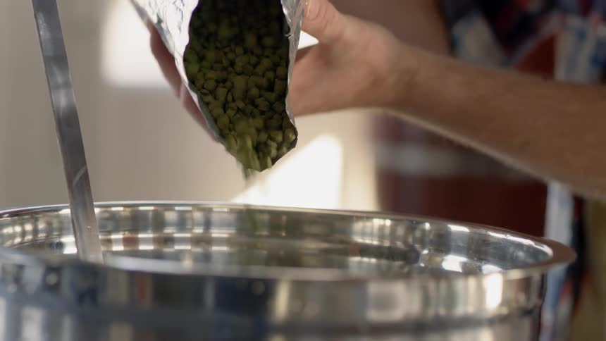 Ingredients are poured into a metal bowl at a brewery