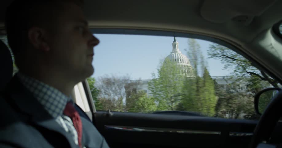 A man is driving on a sunny day
