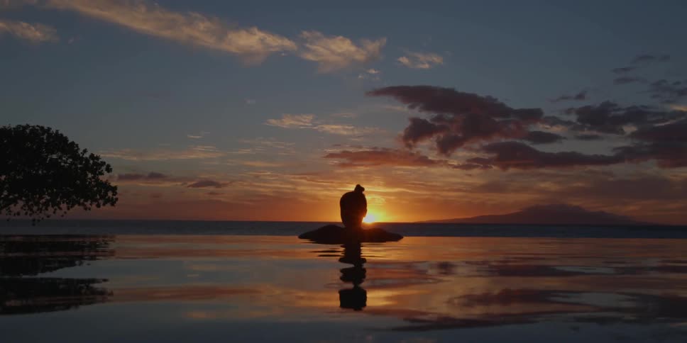 Person floating on the water watching the sun set