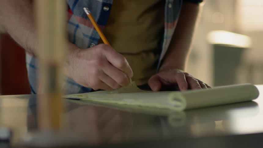 A person is writing on a notepad