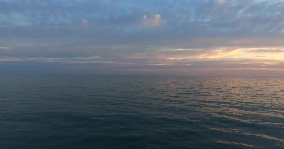 Passing view of the ocean at a cloudy sunset