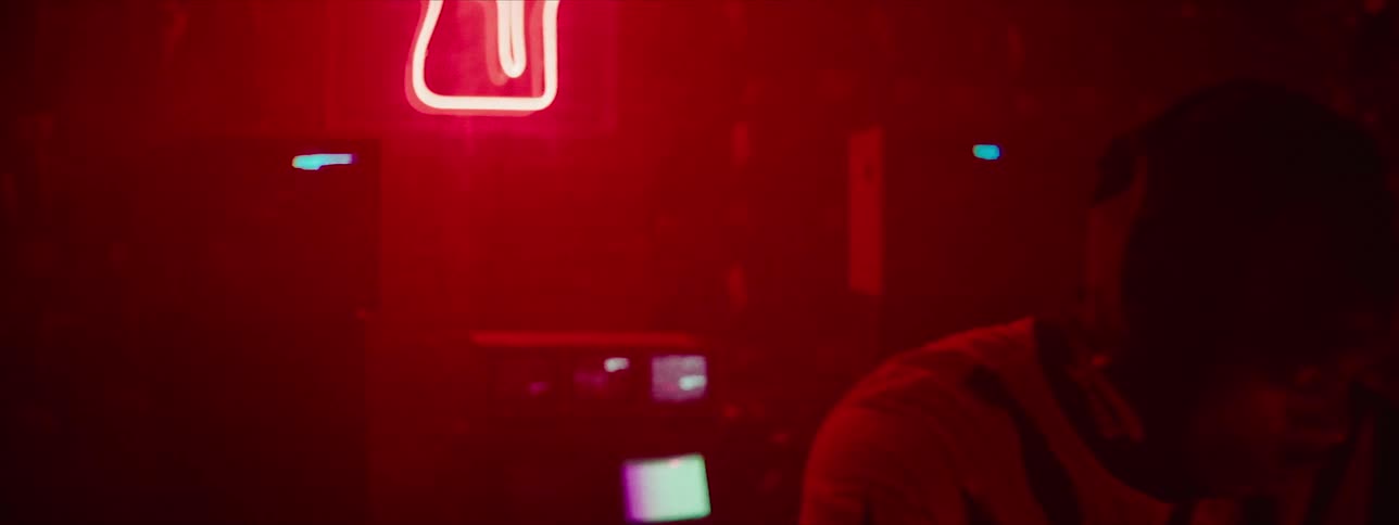 A man removes his hood in a club