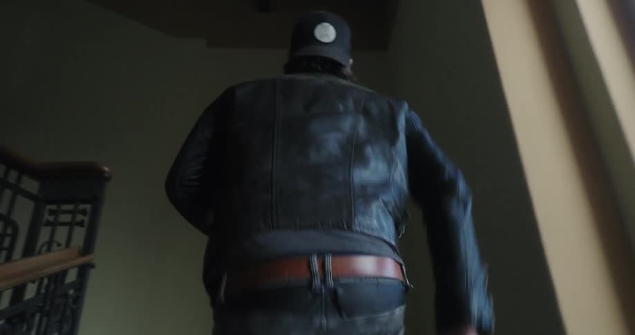 A man in a leather jacket walks up the stairs