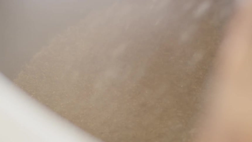 Grain falls into the bin creating dust