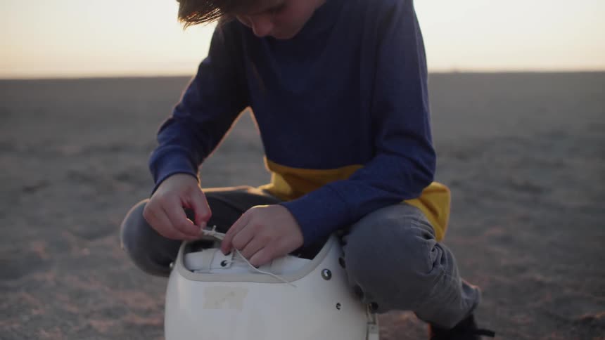 A boy fixes his helmet