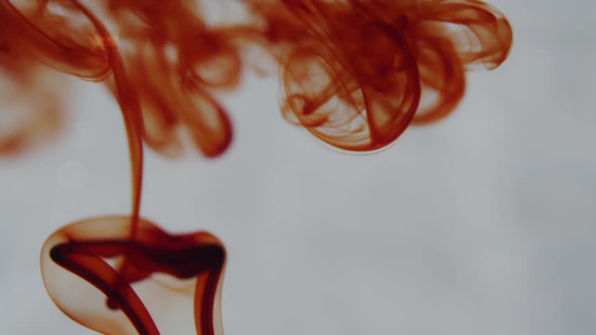 Red liquid swirls as it floats