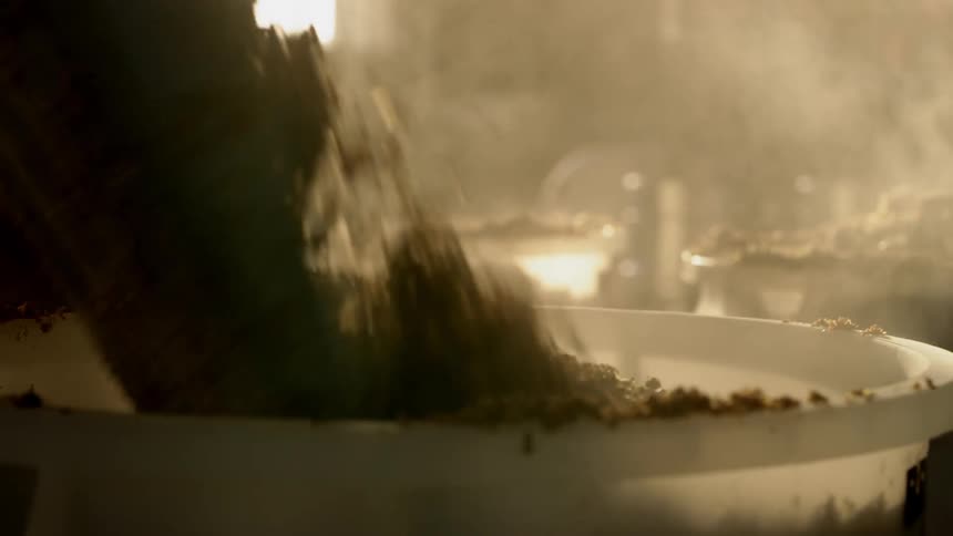 Ingredients are shoveled into a vat in a brewery