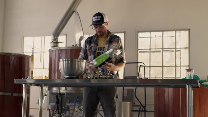 A man is cooking inside a brewery in daylight