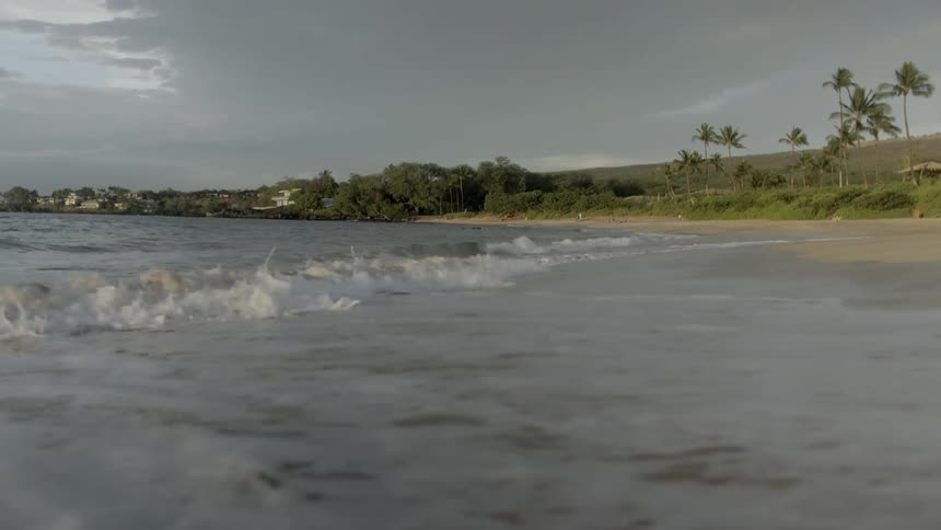 Waves softly crashing on the beach on a cloudy day
