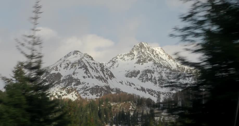 Snow covers two large mountains on a sunny day